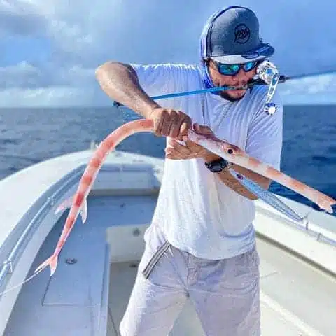 a man dragging a fish in a boat
