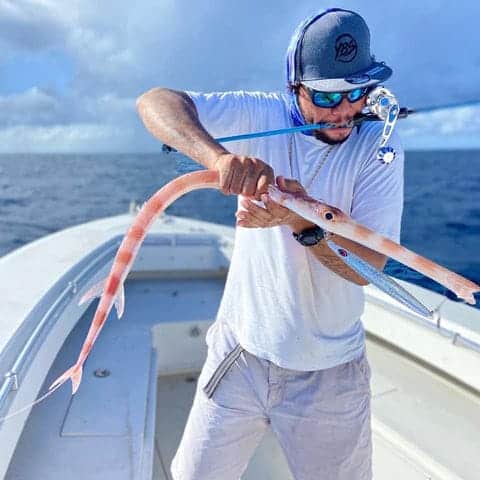 Bass Fishing Tips: How to Catch Bass 4 a man dragging a fish in a boat