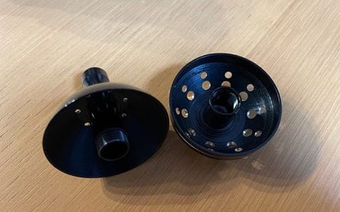Two black fishing reel parts.