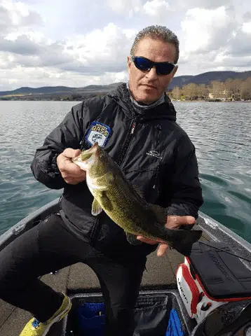 a man showing two fish in a boat