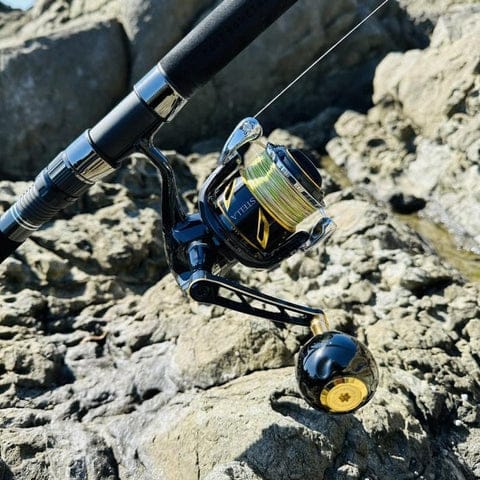 Fishing reel resting on rocky surface.