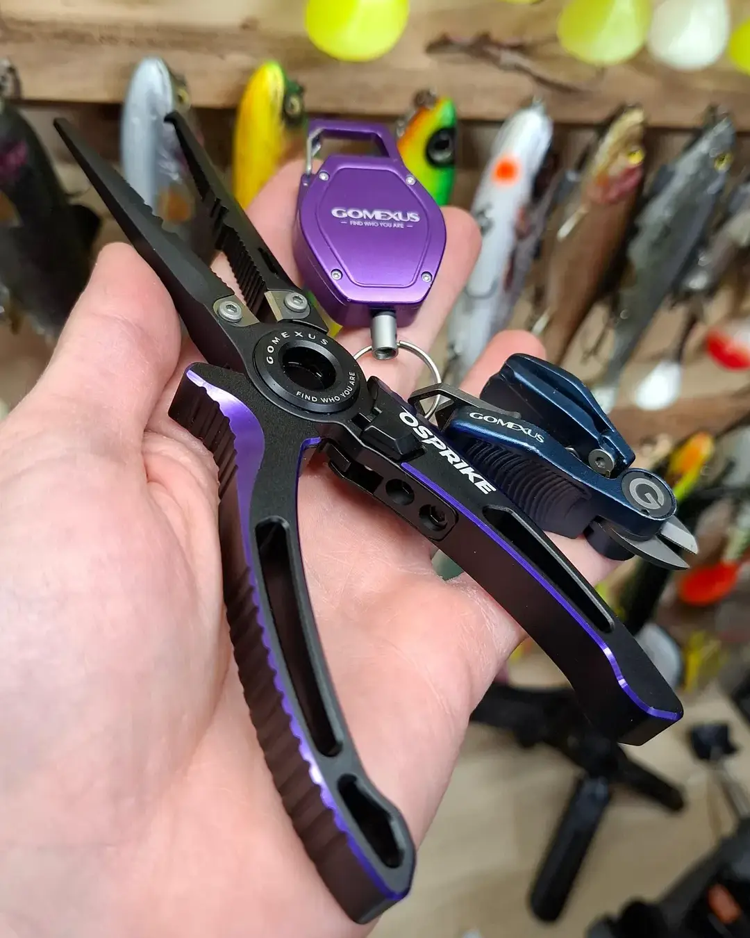 Gomexus-Home 78 Gomexus Osprike aluminum saltwater fishing pliers with a purple CNC zinger retractor and braided line cutter held in hand